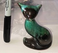 Front view of Blue Mountain Pottery cat beside marker for scale