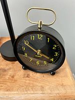 Front view showing clock face, numerals, hands, and top handle