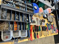 Workbench view showing organiser of fasteners, screwdrivers, hardware containers, hammers and accessories