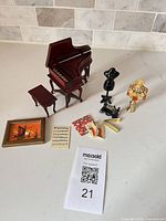 All items arranged showing piano, bench, dress form, sewing machine, lamp, art, papers