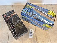 Retail boxes of Curl Secret curler and Ion Shine hot rollers
