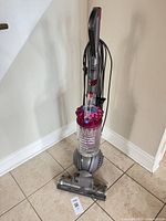 Full view of Dyson DC41 upright vacuum standing on tile floor