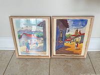 Both framed watercolor paintings side by side