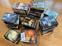 Four stacks of assorted DVD cases on wood floor