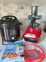 Instant Pot, Farberware food processor, cookbook, red sealing ring on countertop