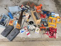 Wide view of entire lot showing bench grinder, vises, saws, torch bottle, clamps, fastener boxes, ratchet straps
