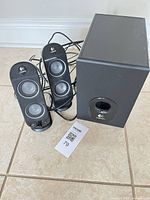 Logitech 2.1 speaker set: two satellites and subwoofer with cables visible