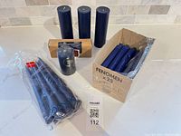 Group of blue candles including IKEA Fenomen box, Dansk pack, three loose pillars, one wrapped pillar, boxed tapers