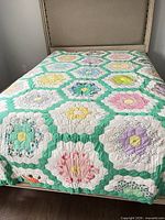 Full view of quilt on queen bed showing overall hexagon flower Garden pattern