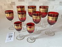 Full set of nine ruby red stemmed glasses showing size variations