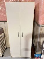 front view of closed cabinet showing white doors and handles