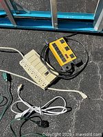Close view of beige power strip and yellow power tap