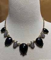 Full view of necklace on display bust showing stone arrangement and chain