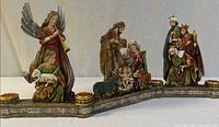 Full view two-section nativity candle holder showing figures and four candle cups