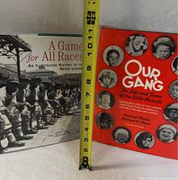 Both hardcover books upright with tape measure showing height ~11 in.