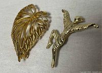 leaf and bird brooches side by side