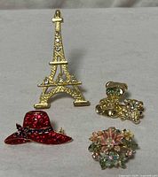 All four brooches displayed together on cloth background