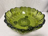Top angled view showing scalloped rim and starburst foot pattern of avocado green glass bowl