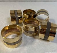 Six brass napkin rings grouped to show exterior finish and quantity