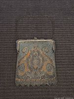 Front view of purse showing design, frame, and handle