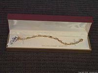 Full view of bracelet in presentation box with tag attached