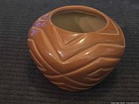 Side view of carved polished clay vase