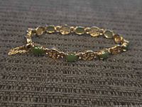 Full view of 900 silver bracelet with alternating green stones and pierced round links