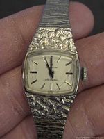 Close-up of watch dial, case texture and crown