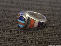 Angled view showing oval multistone inlay top and shoulder details