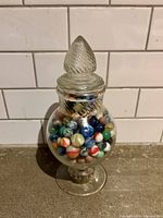 Full view of glass apothecary jar filled with marbles