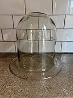 Front view of clear glass dome cloche showing shape and flat rim
