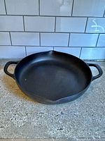 Top view of round cast iron skillet with handles and pour spouts