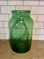 Front view of green glass jar showing size, color and surface texture