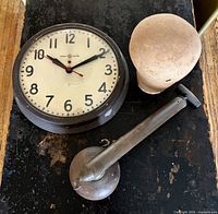 Clock, sprayer, wig block grouped on surface