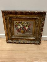 Front view of signed oil floral painting in carved gilt frame
