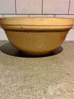 Side view of yellow ware bowl showing glaze and brown band