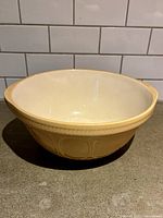 Side view of T.G. Green yellow ware mixing bowl showing interior and exterior color