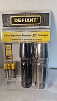 Front view of sealed Defiant 2-pack aluminum LED flashlight set with batteries
