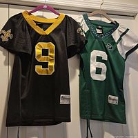 Front view of both jerseys hanging, showing teams, numbers and size appearance