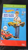 Front of boxed Hot Wheels Ride-Along Baja Truck costume showing product image and branding