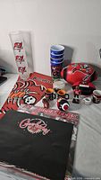 Full lot showing tumblers, stadium cups, footballs, mugs, towel, poster, trophy, candle