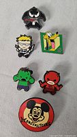 Front view of six assorted enamel pins