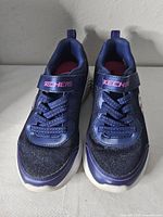 Front view of pair showing uppers, strap branding, toe condition