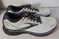 Side view of both sneakers showing mesh uppers, Ghost branding, tread color