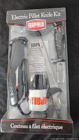 Front view of sealed Rapala electric fillet knife kit showing handle, blade, fork and branding