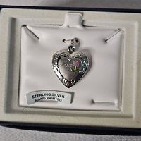 Closed heart locket in box showing front design