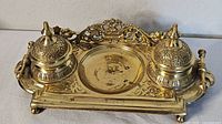 Front view showing full brass inkwell stand with both wells and central recess