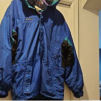 Front view of blue Columbia jacket hanging