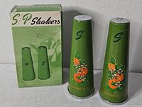 pair of green conical shakers in front of original box