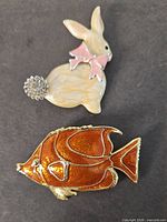 Front view of rabbit and fish brooches
